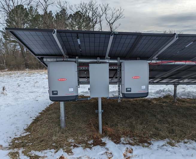Diverse group of solar professionals inspecting MC4 connectors at a training workshop